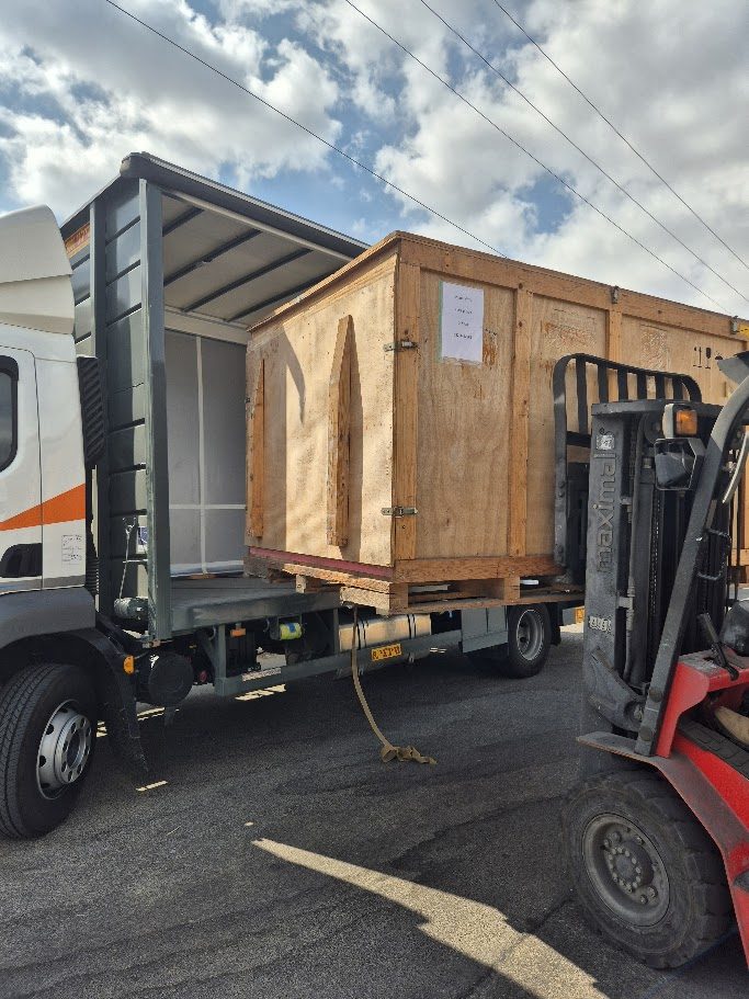 Wooden crate loaded onto a truck with a forklift
