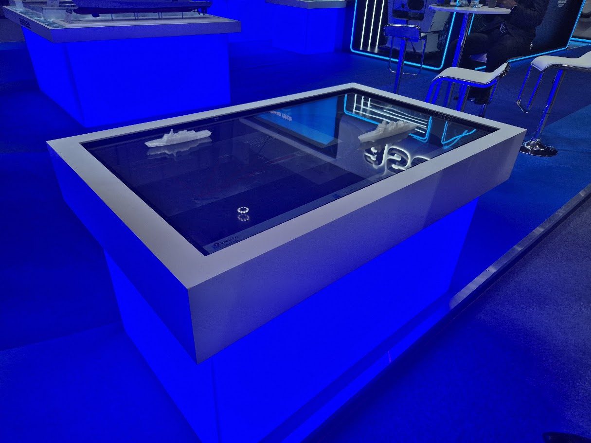 Exhibition display table with scale models at a trade show